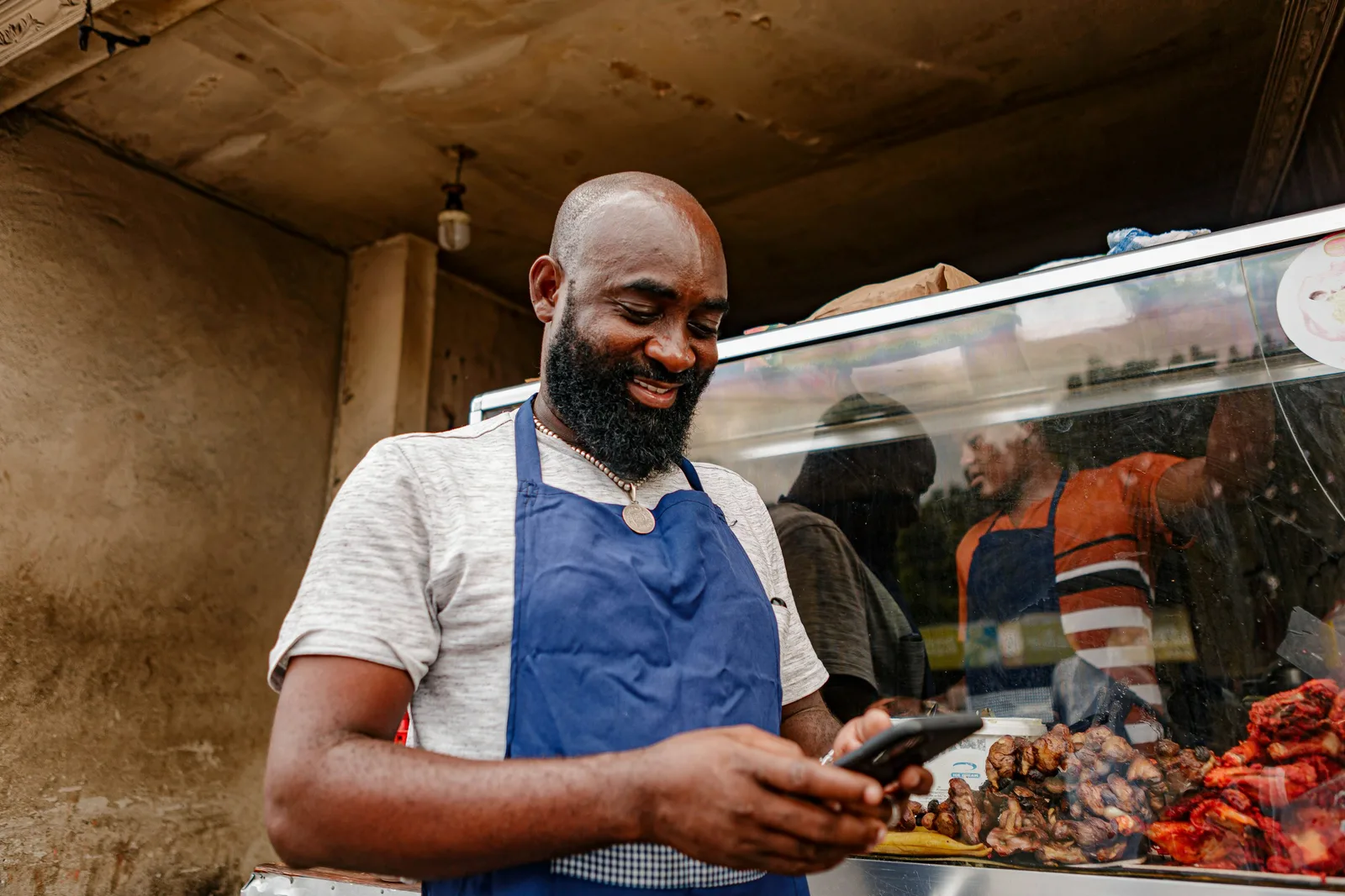 A business owner smiling while checking messages on his phone